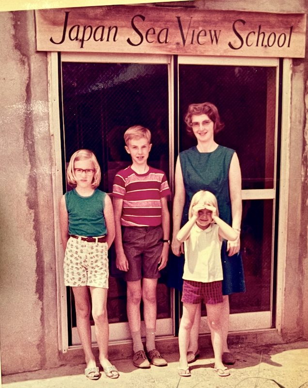 young Marilyn, Larry & Lisa with Carolyn standing at entrance to school building