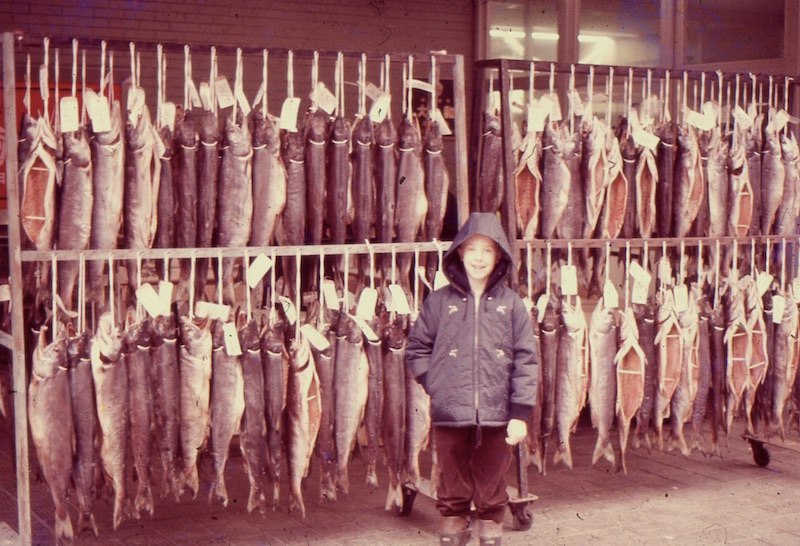 Larry standing in front of racks of dried fish