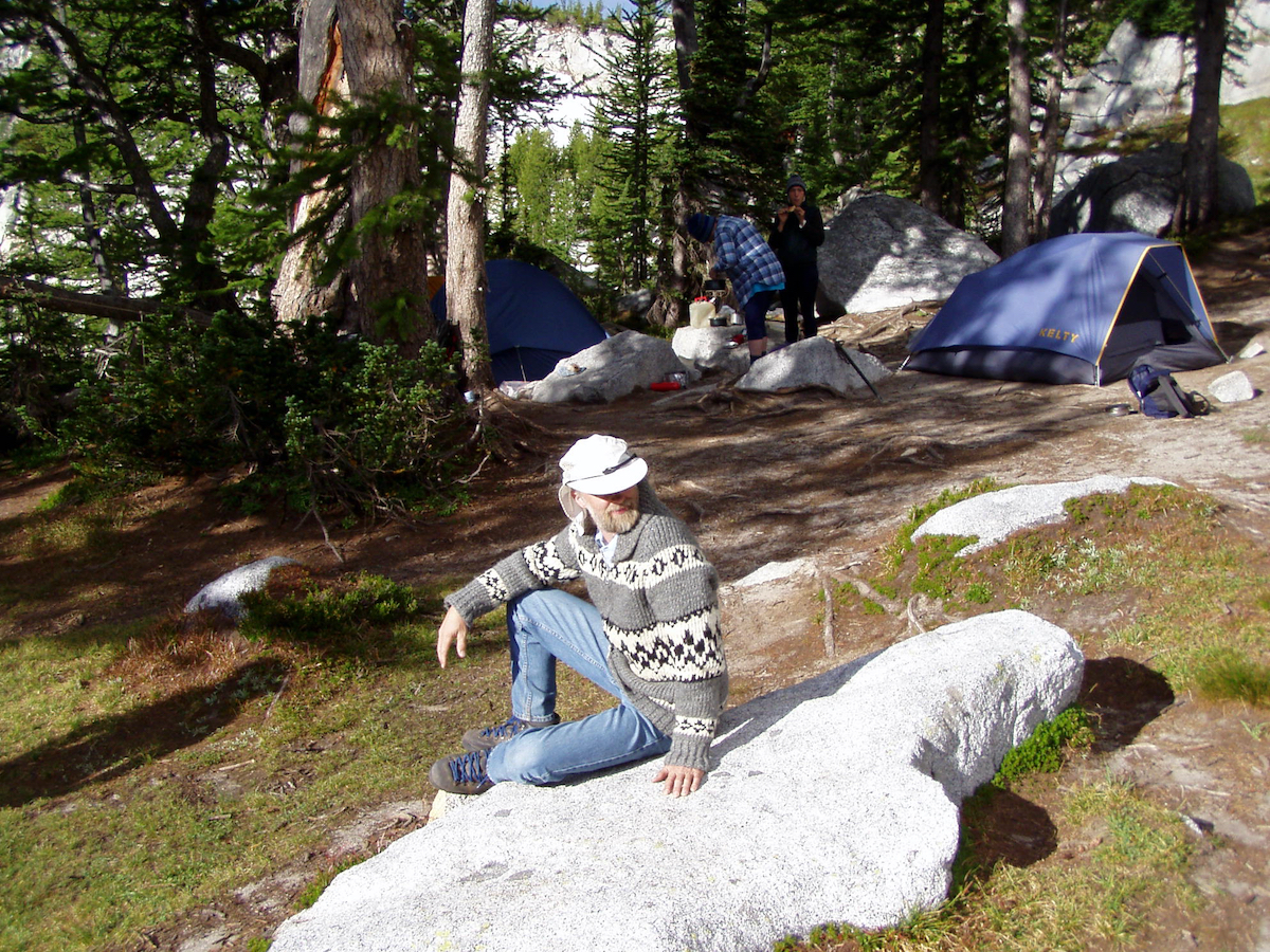 Larry sitting on a boulder by camp site