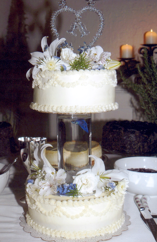 two tier cake with blue gold fish in glass column