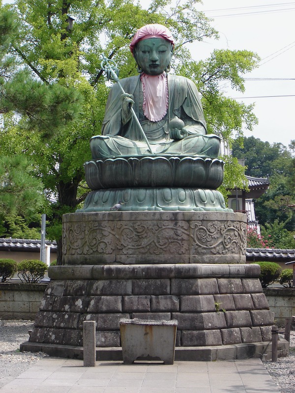 idol with faded red bib and bonnet