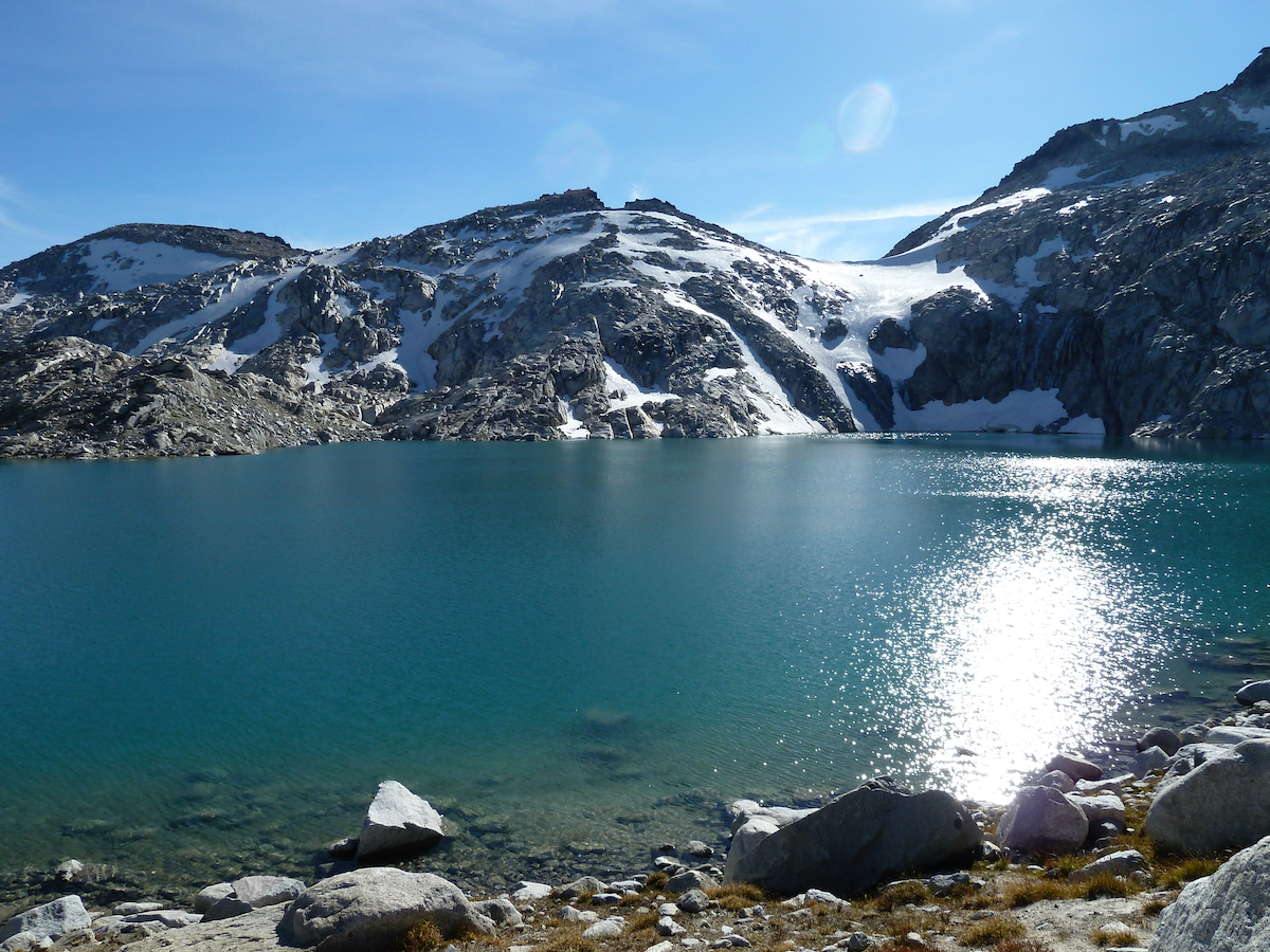 sunlight on lake water, snowy hills in back