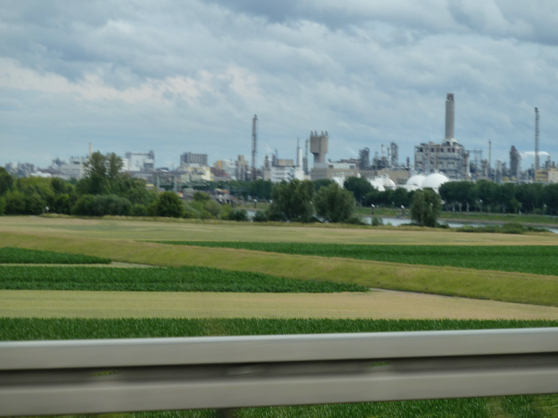 Farm fields with chemical processing buildings in distance