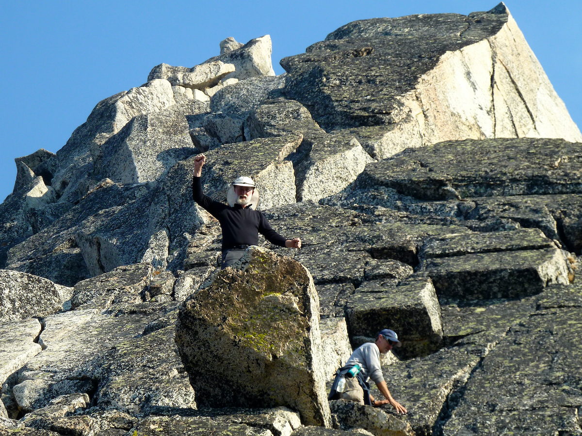 climbers up by the base of a peak above them