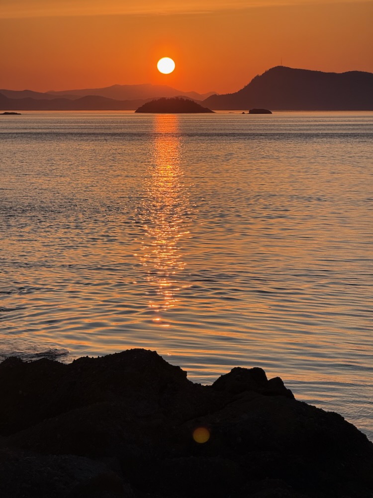 red sun over distant islands and water