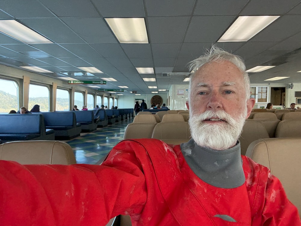 Larry sitting on ferry in dry suit