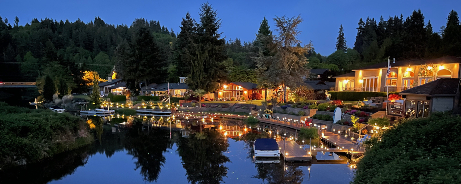 Houses lit up in evening at a river bend