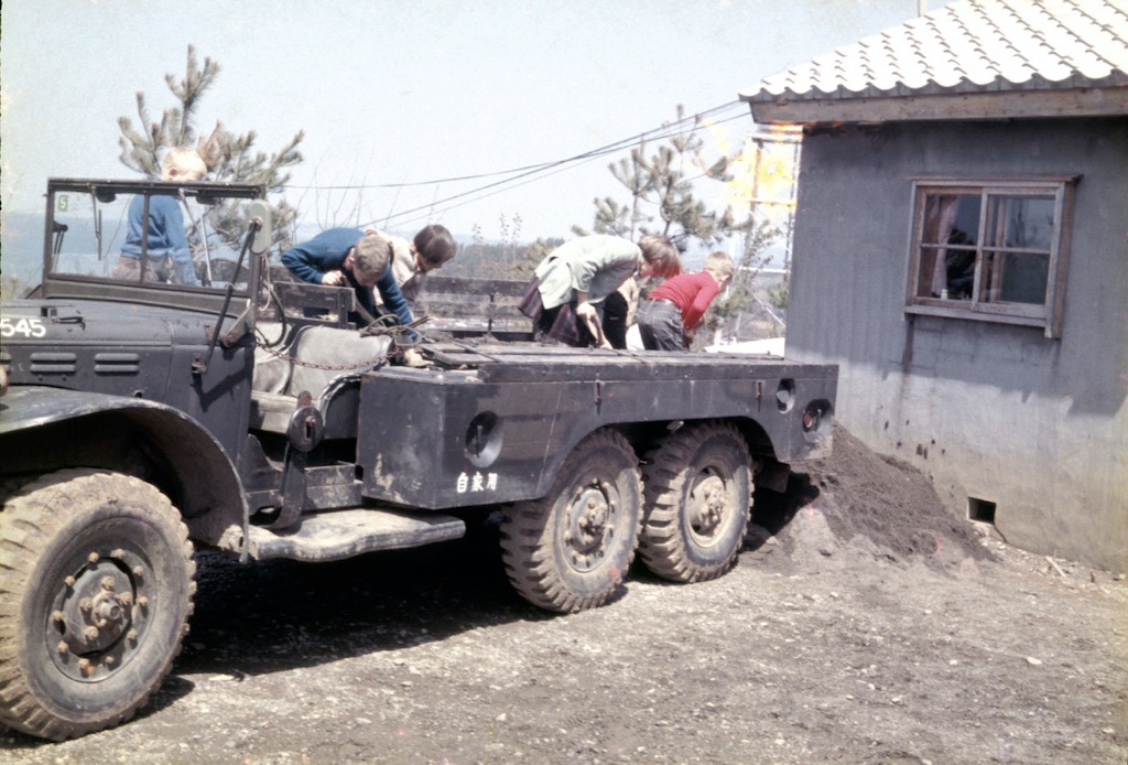 Army truck with dirt being shoveled out